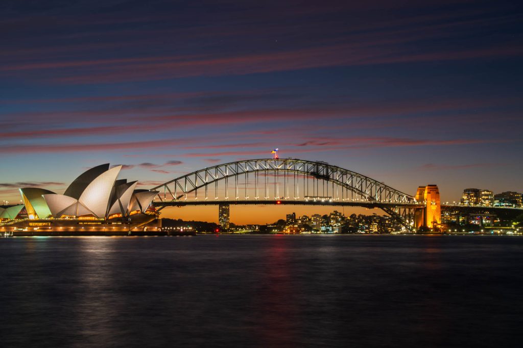 Sydney Opera House and Harbour Bridge across the harbour at dusk