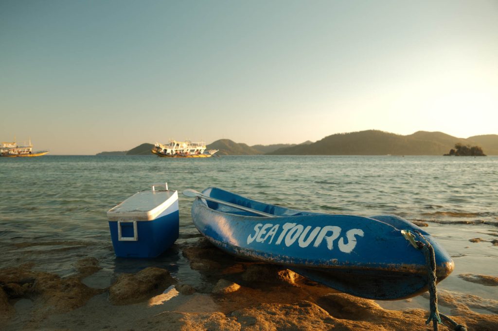 Blue Sea Tours boat on a beach with islands behind